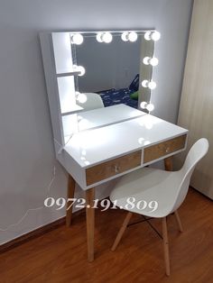 a white vanity with lights on it and a chair