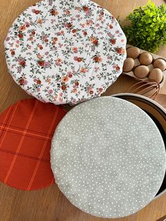 two round plates sitting on top of a wooden table next to pots and pans