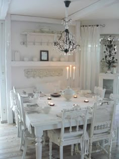 a white dining room table with candles on it