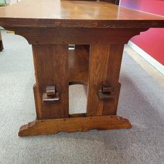 a wooden table sitting on top of a carpeted floor