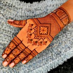 a woman's hand with henna tattoos on it