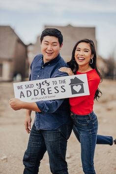 a man and woman holding a sign that says we said yes to the address