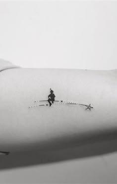 a small tattoo on the arm of a person with skis and stars in the sky