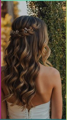 the back of a woman's head with long hair and flowers in her hair