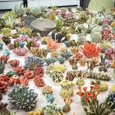 a table topped with lots of fake cactus plants