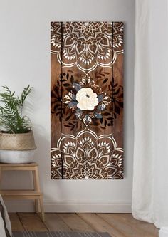 a white flower on a wood paneled wall next to a potted green plant