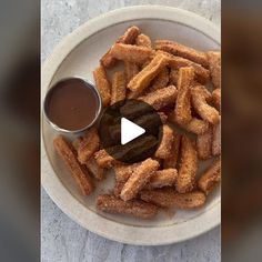 a white plate topped with churros and dipping sauce