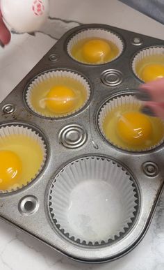 an egg being cooked in a muffin tin