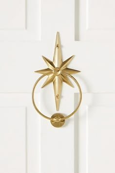 a door handle with a star design on the front and back of it, hanging from a white door