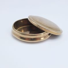 two small round metal containers on a white surface