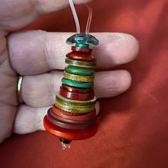 a person is holding a colorful bead ornament