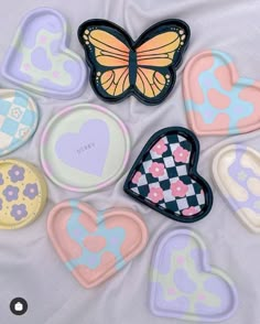 six heart shaped cookie cutters on a white sheet with butterfly and checkerboard design