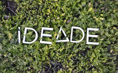 the word deade written in white letters on top of green plants