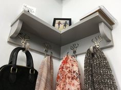 three purses are hanging from hooks on the wall