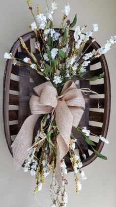 a bunch of flowers that are sitting in a vase on a wall with a bow