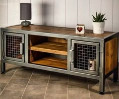 a metal and wood sideboard with two baskets on the top, next to a potted plant