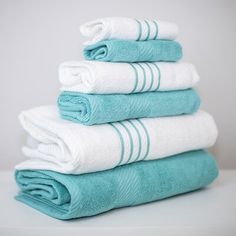 five towels stacked on top of each other in blue and white colors, all folded neatly