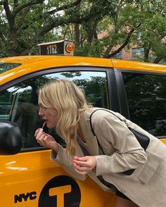 a woman leaning out the window of a taxi