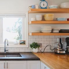 the kitchen counter is clean and ready to be used for cooking or baking, as well as dishes on shelves