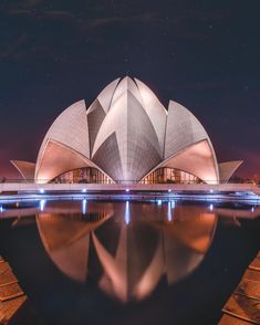 the lotus shaped building is lit up at night