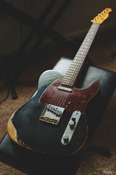 an electric guitar sitting on top of a black case