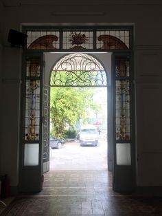 an open door leading to a car parked in front of the entrance into a building