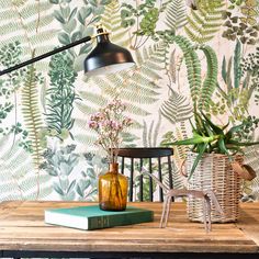 a wooden table topped with a lamp next to a book and plant on top of it