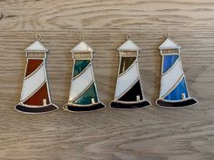 three different colored lighthouses sitting on top of a wooden table