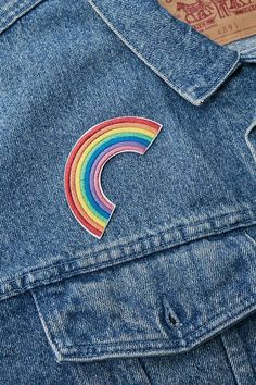 a rainbow patch on the back of a jean jacket