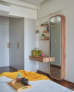 a bedroom with a bed, mirror and shelf