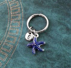 a blue starfish keychain with the letter e on it's side