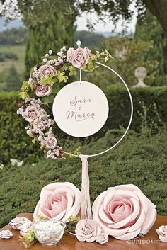 a table topped with pink flowers and a white sign