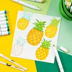 the pineapples are drawn on paper next to crayons