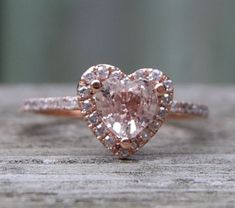 a heart shaped diamond ring on top of a wooden table