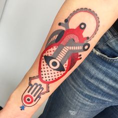 a person with a tattoo on their arm has a red and black design on it