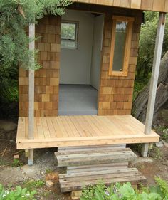 a small wooden building sitting in the middle of a forest