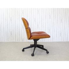 a brown leather office chair sitting on top of a white floor