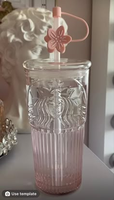 a glass cup with a flower on the top