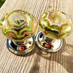 two glass door knobs sitting on top of a wooden table