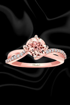 a pink diamond engagement ring on a black background