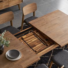 a wooden table with two chairs next to it and a bowl on the table top