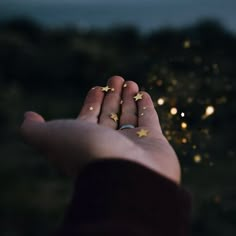 a person's hand with two gold stars on it, and the sky in the background