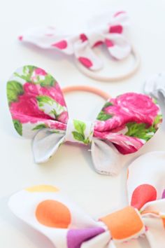 three bow ties with flowers on them sitting next to each other in front of a white background