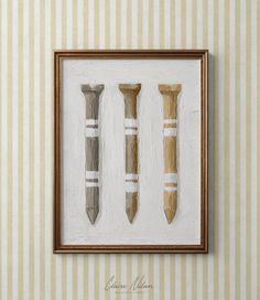 three framed objects are hanging on the wall in front of a beige striped wallpaper