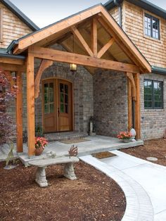 the front entrance to a home with a stone walkway leading up to it and a bench on the side