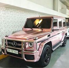 a pink mercedes g - class parked in a garage