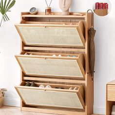 a wooden shoe rack filled with shoes next to a wall mounted vase and planter