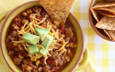 a bowl filled with chili, corn and tortilla chips