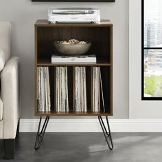 an entertainment center with vinyl records and a bowl of cereal on it's stand