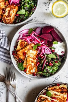 two bowls filled with chicken, beets and salad